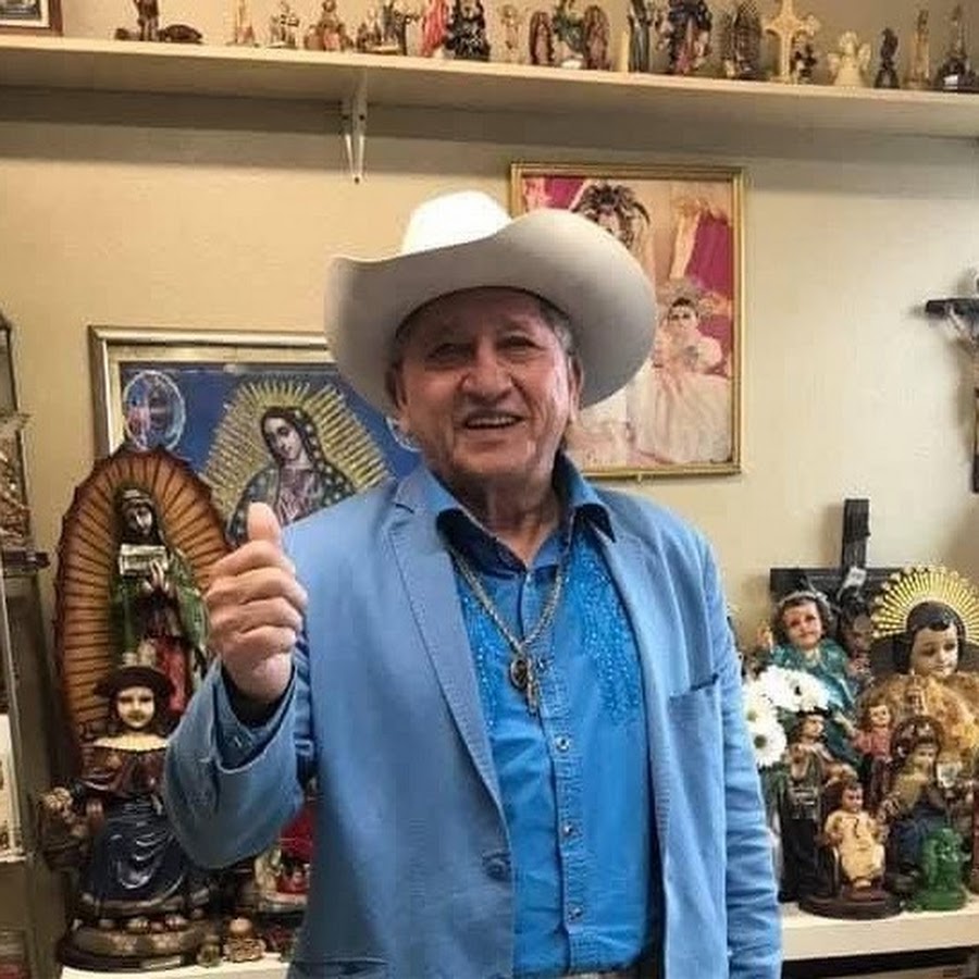 Óscar Interiano sonriendo, con sombrero blanco y traje azul